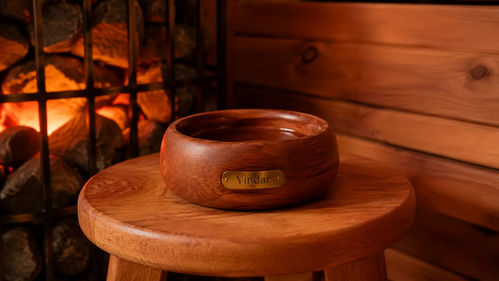 Cedar aromatherapy bowl placed a safe distance from glowing heater rocks inside a home sauna