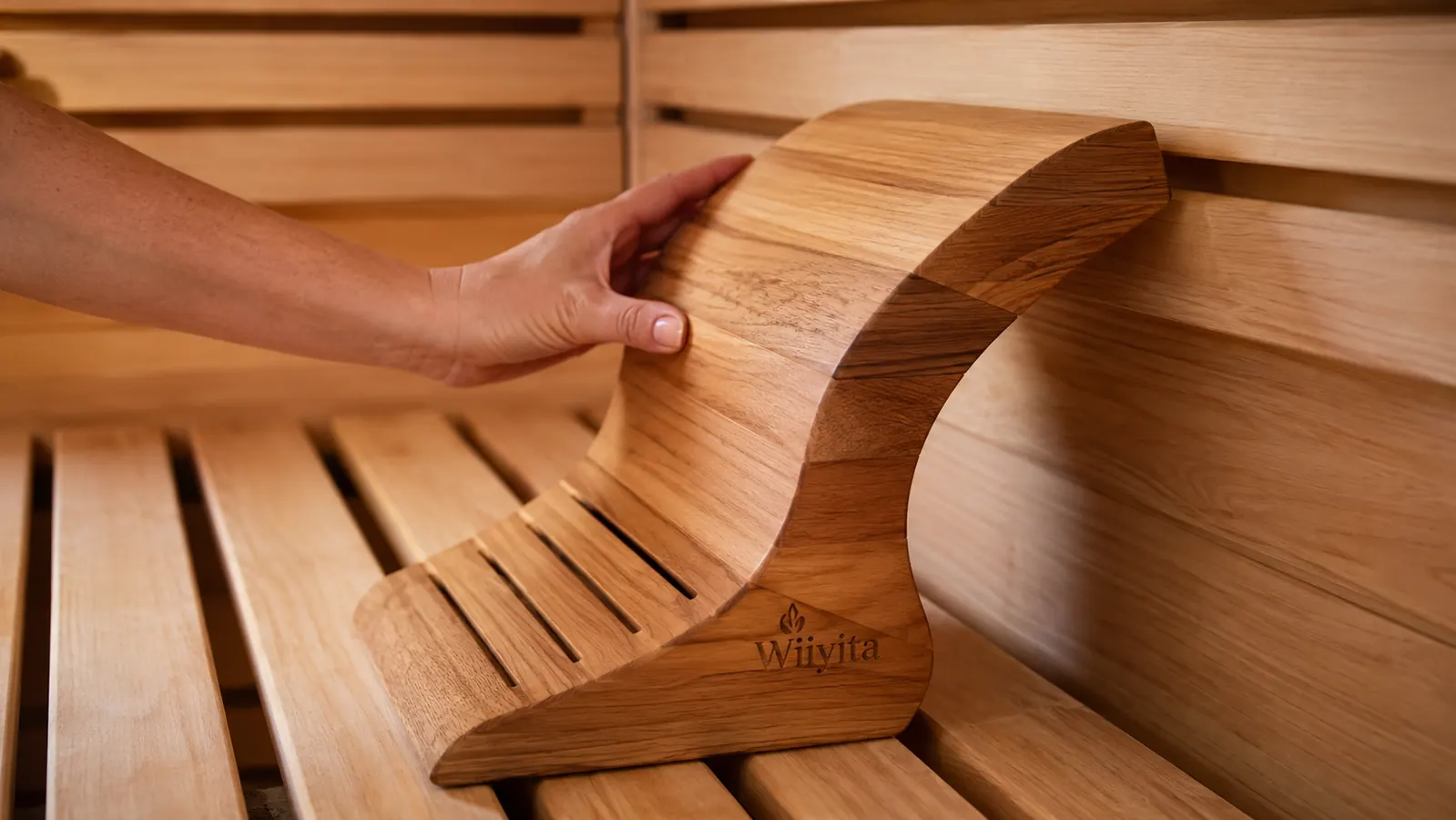 Hand positioning the Wiiyita sauna backrest against the bench before a session